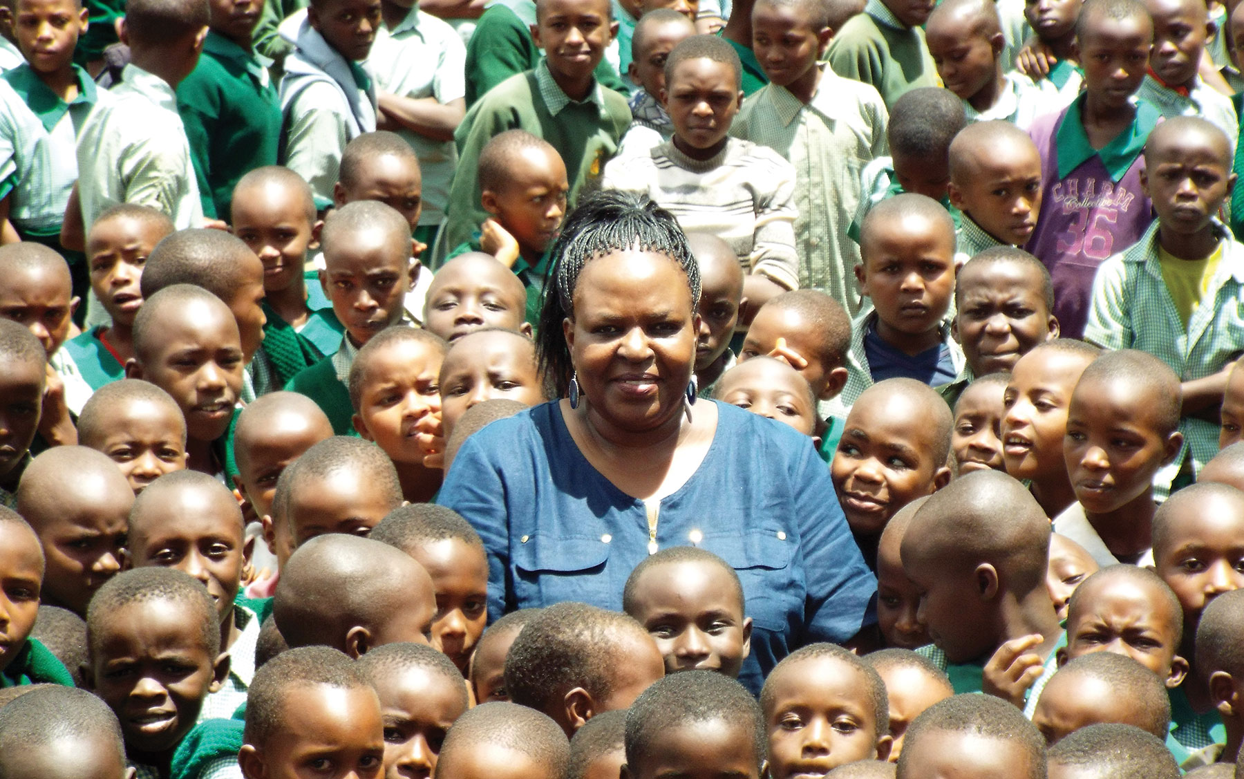 Purity in the middle of some of the children fed daily in the Sister2Sister Feeding Program